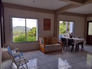 a living room with a table and chairs and windows at Refúgio na Serra Gaúcha in Nova Petrópolis