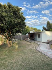 a house with a tree in the yard at House in La Tuna in Balneario Argentino