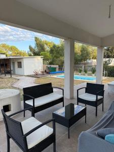 a patio with chairs and tables and a pool at House in La Tuna in Balneario Argentino