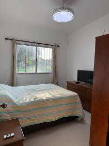 a bedroom with a bed and a window at House in La Tuna in Balneario Argentino