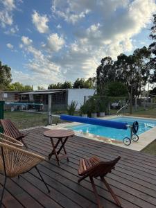 a deck with two chairs and a table and a pool at House in La Tuna in Balneario Argentino +7 photos