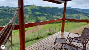 a porch with chairs and a view of a mountain at Oasis na montanha in Bueno Brandão