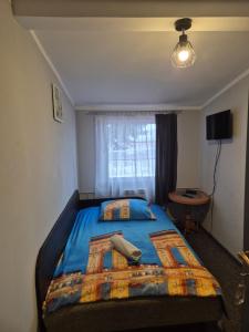 a bedroom with a large bed with a blue comforter at Zajazd pod Lwem in Trzebnica +60 photos