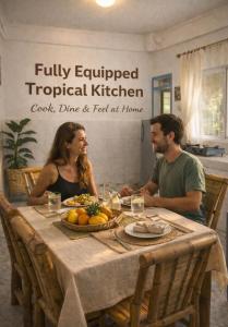 a man and woman sitting at a table with food at Sun House Rental in Mambajao