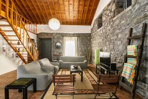 a living room with a stone wall at Casa Miradouro do Pesqueiro in Feteira Grande