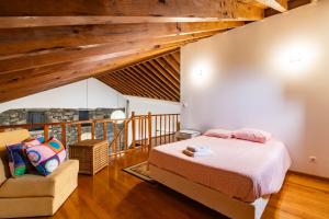 a bedroom with a bed and a chair at Casa Miradouro do Pesqueiro in Feteira Grande