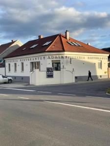 a man walking in front of a white building at daroomz in Gloggnitz
