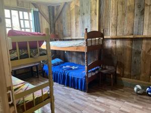 a bedroom with two bunk beds and a desk at Galpão, Pousada Paraíso do Arruda in Lages