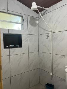 a bathroom with a shower with a television in it at Galpão, Pousada Paraíso do Arruda in Lages +13 photos