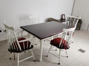 a table with three chairs and a table and a table at Departamento 2 Viedma Centro in Viedma