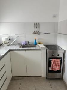 a white kitchen with a sink and a stove at Departamento 2 Viedma Centro in Viedma