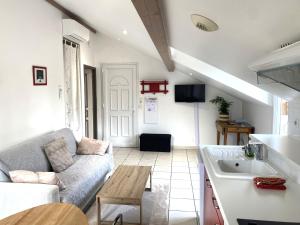 a living room with a couch and a table at Puravida Apparts in Lagnieu