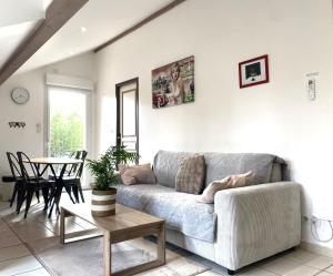 a living room with a couch and a table at Puravida Apparts in Lagnieu