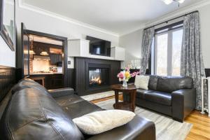 a living room with a leather couch and a fireplace at Château Saint-Émile in Namur