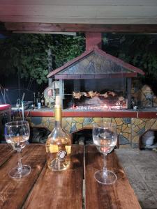 a bottle of wine and two wine glasses on a table at Apartment 1 by Villa Ceni in Elbasan