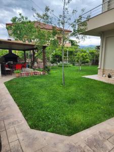 a green yard with a pavilion and a tree at Apartment 1 by Villa Ceni in Elbasan