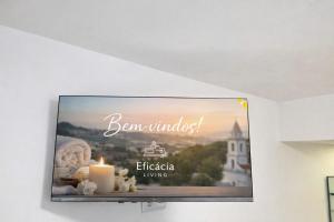 a flat screen tv hanging on a wall with a candle at Spa & Jacuzzi Dupla Privada Escapadinha Romântica Abrantes in Abrantes