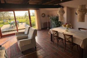 a dining room with a table and chairs and a patio at De Beijersche Stee , Landhuysje in Stolwijk