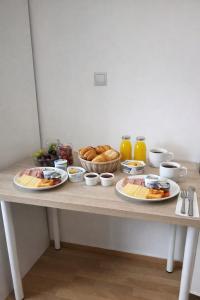 a table with plates of food and bowls of bread at Spa & Jacuzzi Dupla Privada Escapadinha Romântica Abrantes in Abrantes +4 photos