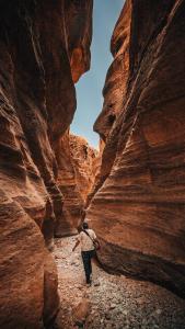a man walking through a slot canyon at Night in Dana in Dana