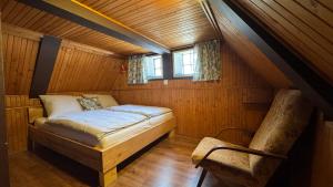 a bedroom with a bed and a chair in a attic at Chaloupka za mostem Plavy - Jizerské hory in Plavy