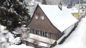 a house covered in snow with a roof at Chaloupka za mostem Plavy - Jizerské hory in Plavy