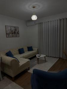 a living room with a couch and a table at Golden Apartment 1 in Kamëz +4 photos