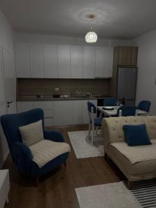 a living room with a couch and chairs and a table at Golden Apartment 1 in Kamëz