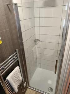 a bathroom with a shower with a glass door at Ye Olde Crown in Edenbridge