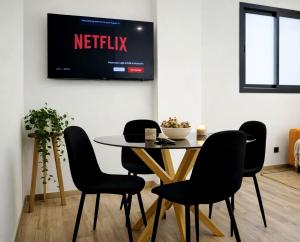 a table and chairs with a television on a wall at Bigbass Valencia Centro in Valencia +4 photos
