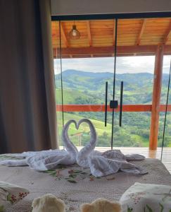two swans making a heart on a bed in front of a window at Oasis na montanha in Bueno Brandão +40 photos