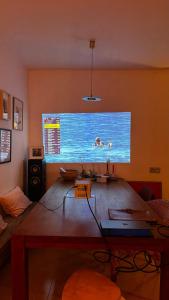 a living room with a large window with two people in the water at Sabinas place in Corralejo
