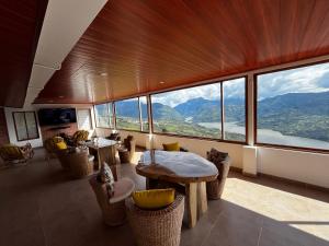 a room with a table and chairs and windows at Villa Celeste in Macanal