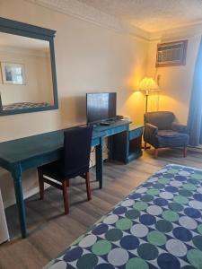 a room with a desk and a chair and a mirror at Moosomin Country Squire Inn in Moosomin