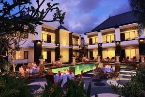 a resort with a swimming pool and tables and chairs at The Radiant Hotel in Kuta +56 photos