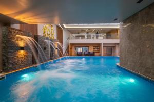 a large swimming pool with water fountains in a building at Kasbel 2 Appart & Pool in Marrakesh