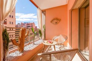 a balcony with chairs and a table and a cactus at Kasbel 2 Appart & Pool in Marrakesh