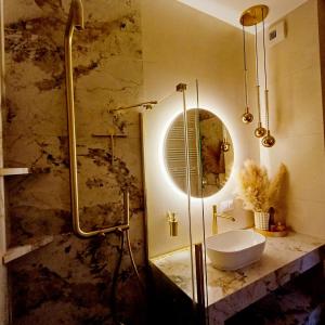 a bathroom with a sink and a shower with a mirror at Apartament Eleven Międzyzdroje in Międzyzdroje +19 photos