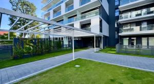 a large building with a lawn in front of it at Apartament Eleven Międzyzdroje in Międzyzdroje