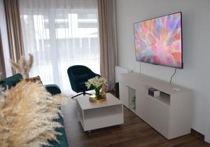 a living room with a couch and a flat screen tv at Apartament Eleven Międzyzdroje in Międzyzdroje