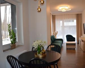a living room with a table and chairs and a couch at Apartament Eleven Międzyzdroje in Międzyzdroje