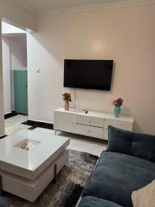 a living room with a couch and a tv on a wall at Luxx Homes #Unit B in Ruiru