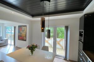 a living room with a table with a vase of flowers at Trolltunga Fjordview House, Odda in Odda
