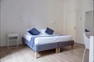 a bedroom with a bed with blue pillows on it at Urban Stay Siena in Siena