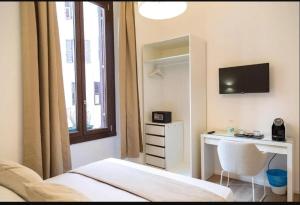 a bedroom with a bed and a desk and a television at Urban Stay Siena in Siena