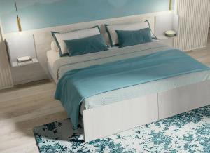 a bedroom with a large bed with blue pillows at Urban Stay Siena in Siena