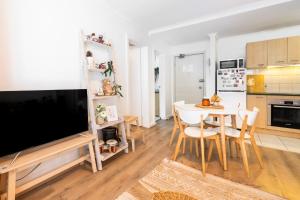 a kitchen and dining room with a table and a television at Boho by the Bay in Melbourne