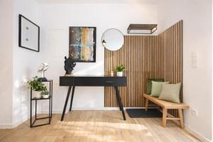a desk with a mirror and a chair in a room at Nivas Collection - Neubau Luxus Apartment in Montabaur