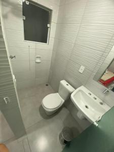 a white bathroom with a toilet and a sink at Hotel Fênix II Butantã in São Paulo