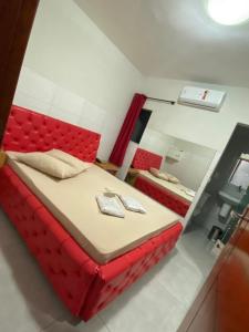 a red bed in a room with a mirror at Hotel Fênix II Butantã in São Paulo +2 photos